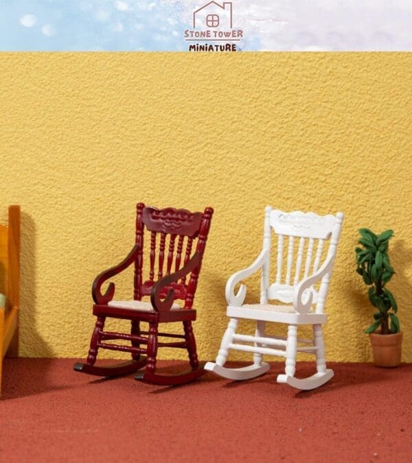 Two miniature rocking chairs, one red and one white, placed against a textured yellow wall with a small plant nearby.