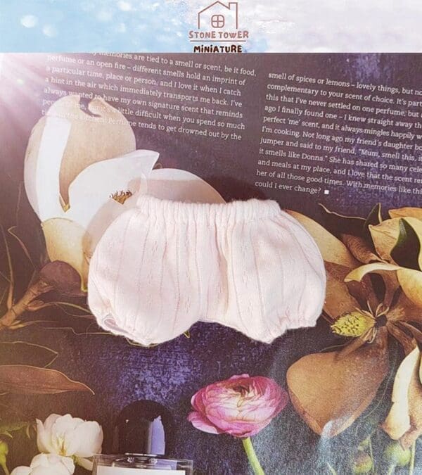 Small white bloomers on a floral magazine background with text and a "Stone Tower Miniature" logo at the top.