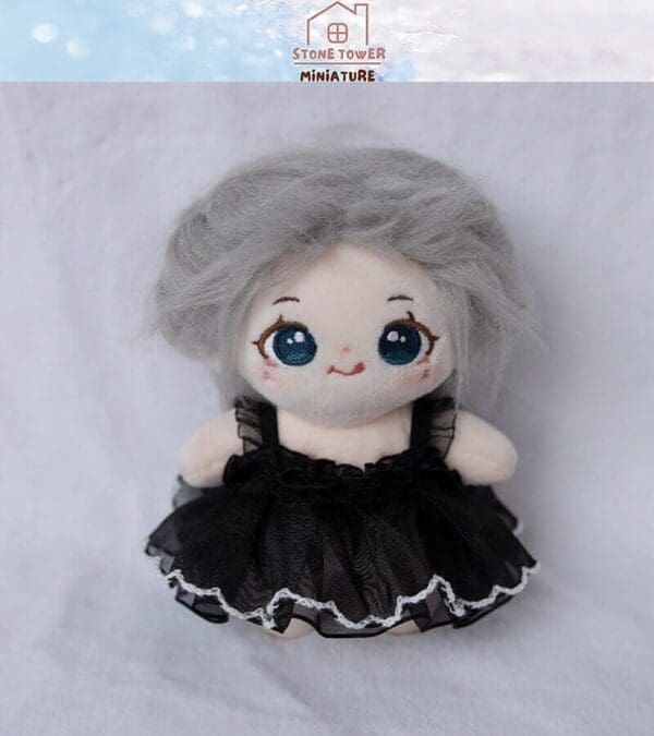 Plush doll with gray hair and blue eyes wearing a black lace dress, set against a soft background.