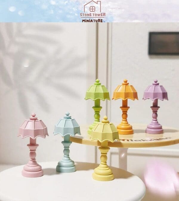 Colorful miniature lamps in pastel shades displayed on small round tables indoors.