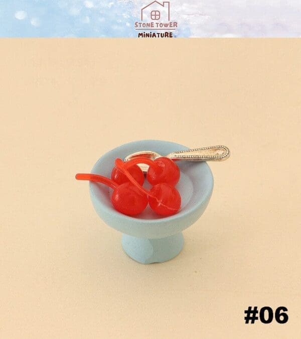 Miniature red cherries with a fork on a light blue pedestal dish. Text reads "Stone Tower Miniature #06.